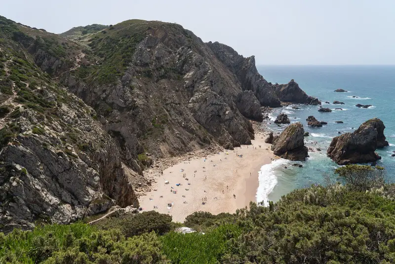 Praia da Ursa vista do miradouro, com os rochedos no mar